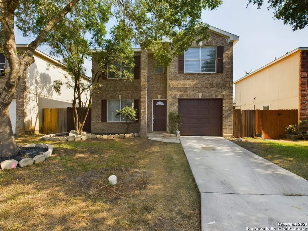 a view of a house with a backyard and a tree