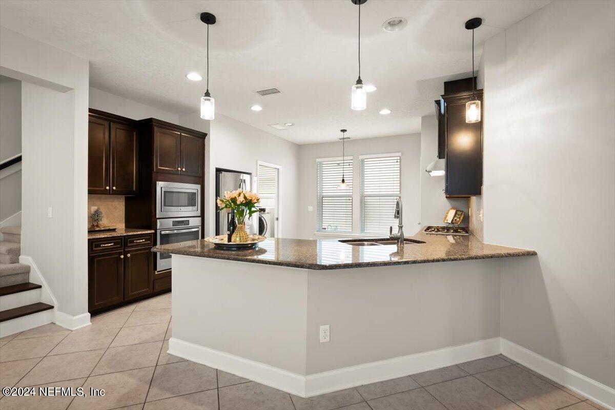 a kitchen with stainless steel appliances granite countertop a sink a stove and refrigerator