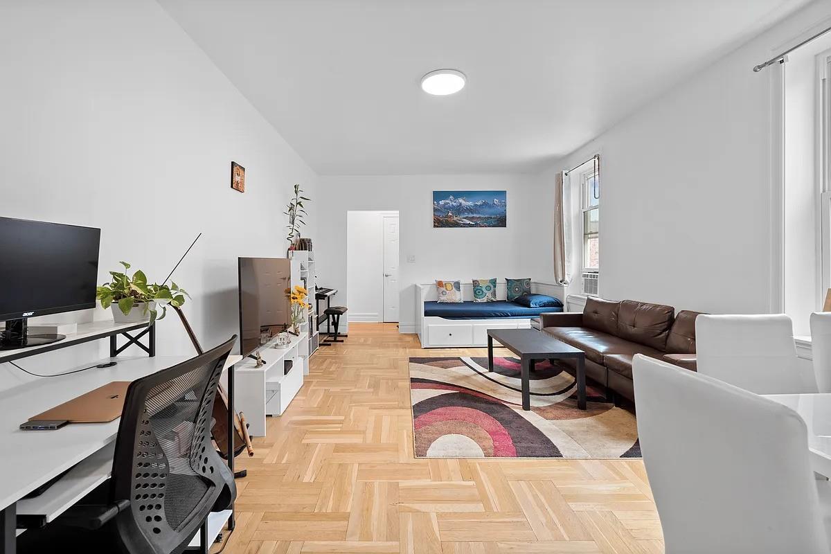 a living room with furniture a flat screen tv and a window