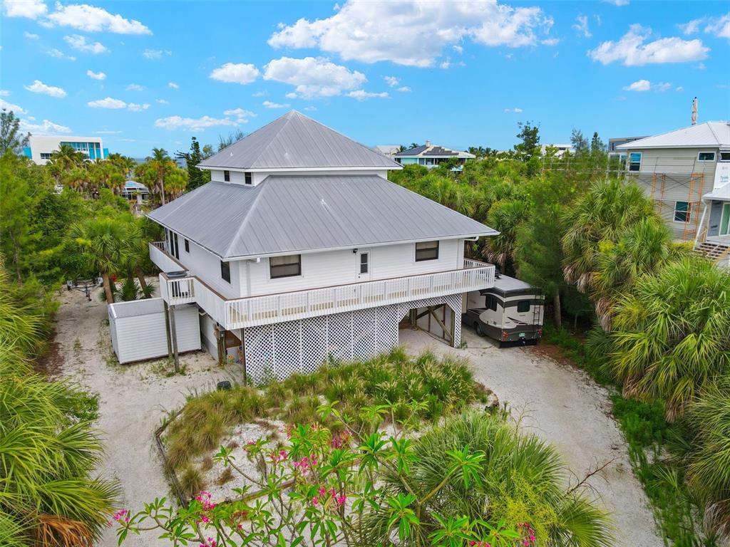 an aerial view of a house with table and chairs under an umbrella