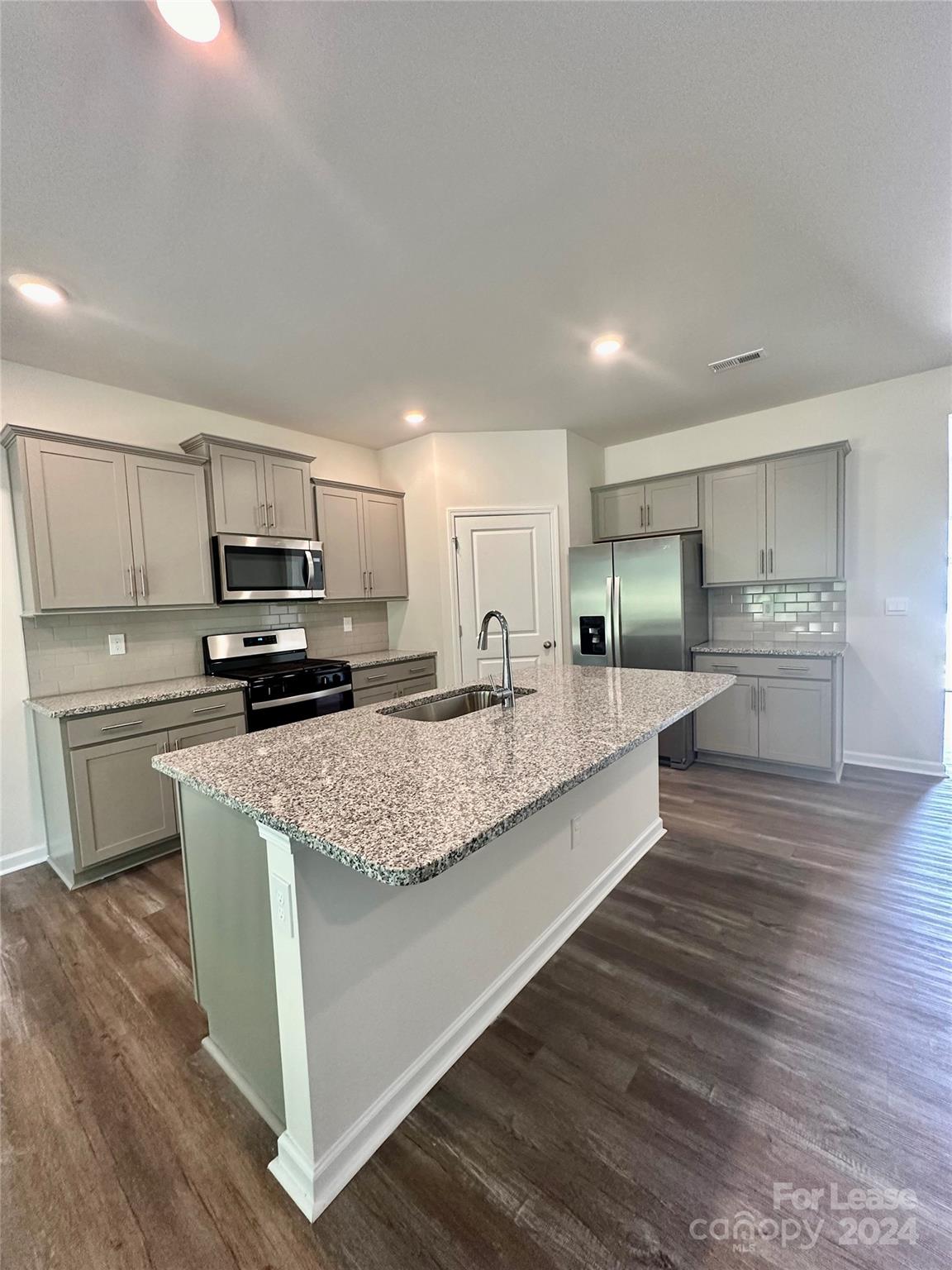 a large kitchen with a center island and stainless steel appliances