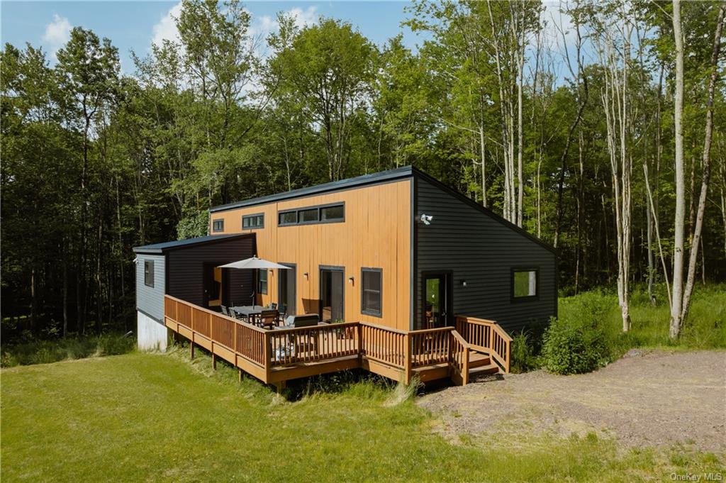 Back of house featuring a yard and a deck