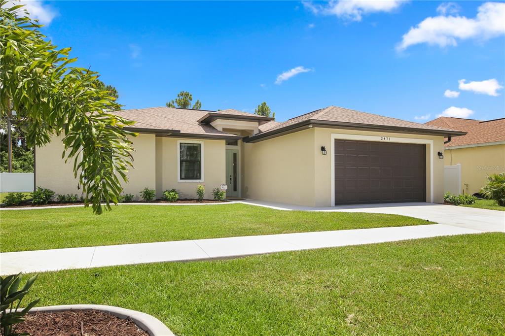 a front view of a house with a yard and garage