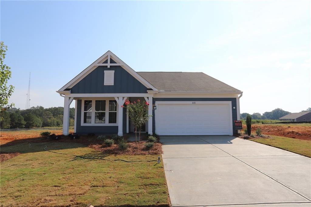 a front view of house with yard and trees in the background