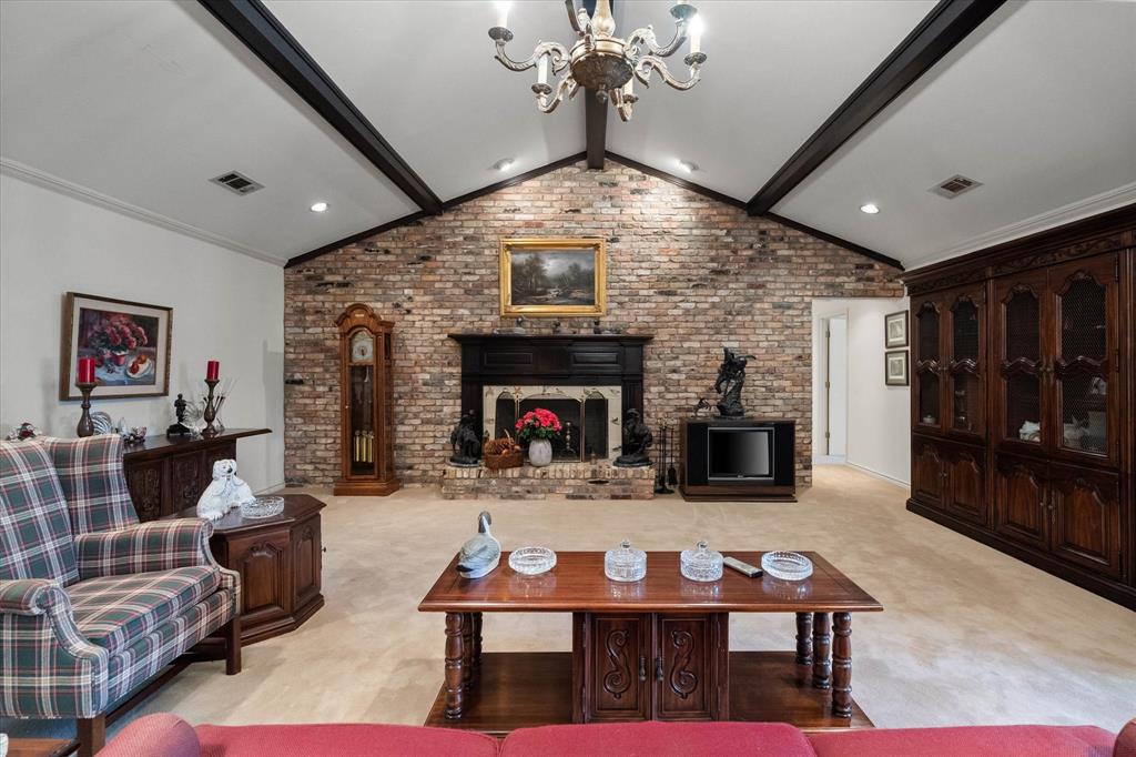 a living room with furniture a fireplace and a chandelier