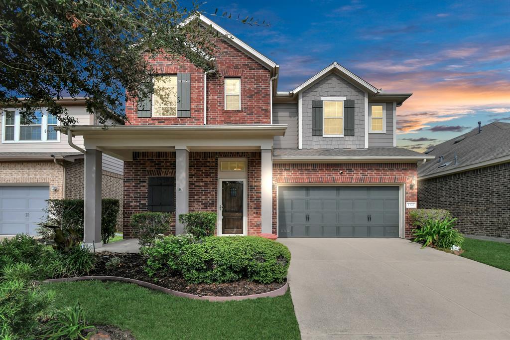 front view of a brick house with a yard