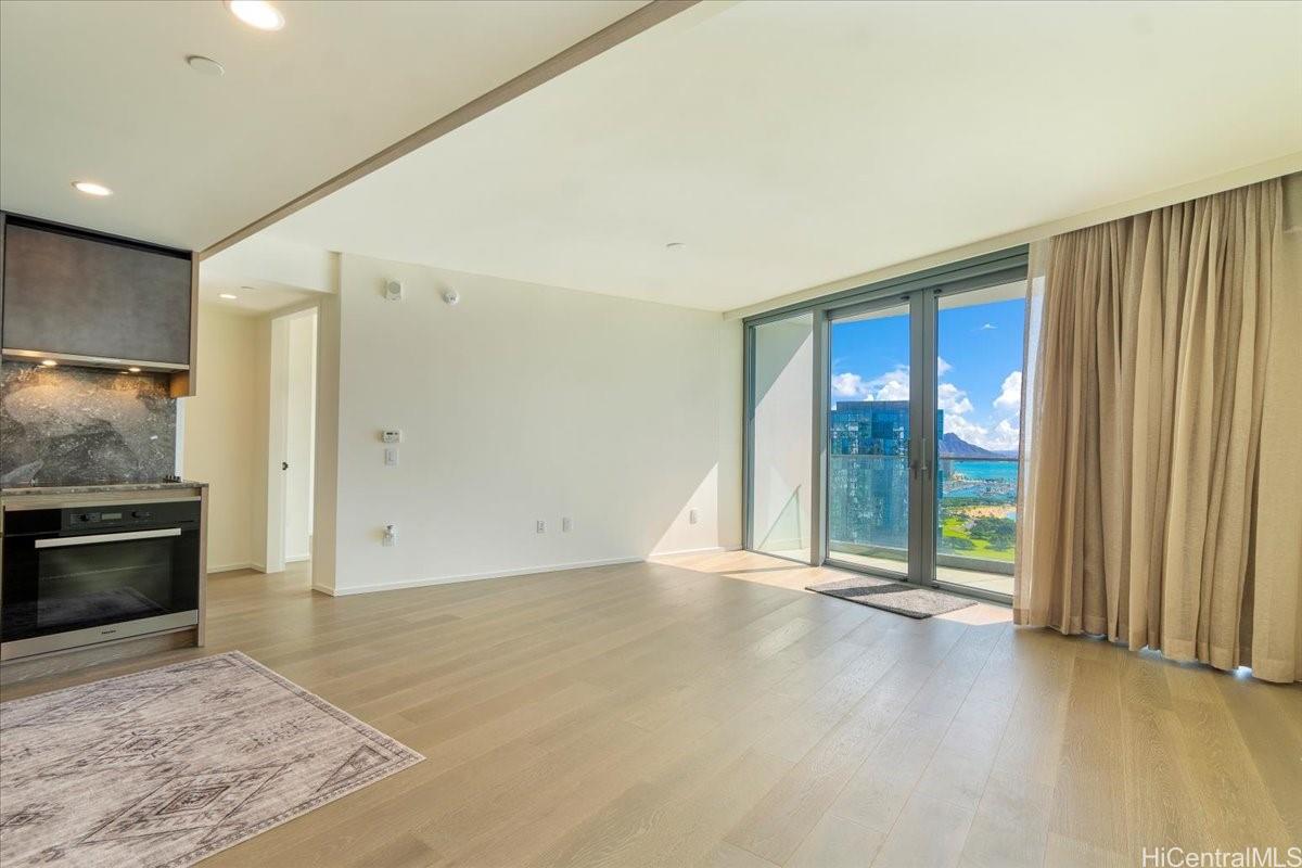 an empty room with floor to ceiling window and an outdoor view