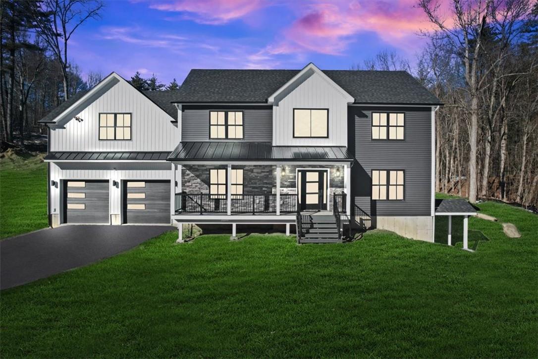 View of front facade featuring a yard and a garage