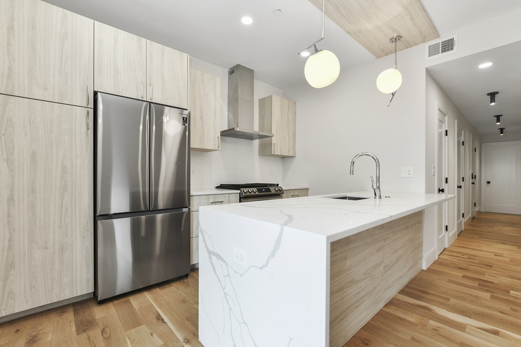 a kitchen with stainless steel appliances a refrigerator sink and cabinets