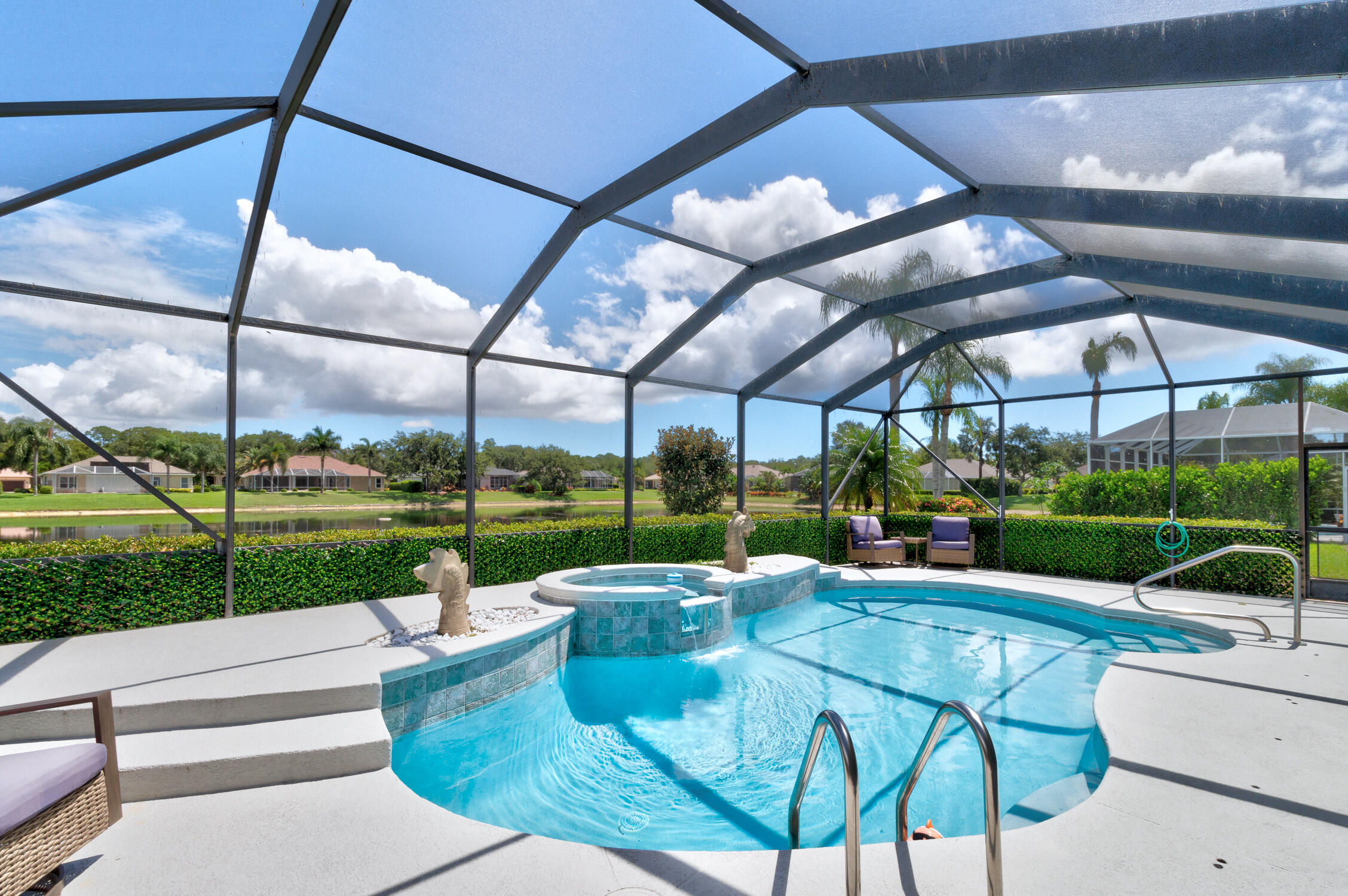 a view of a swimming pool with a couches chairs and table in patio