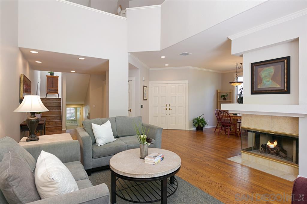 a living room with furniture a fireplace and a chandelier