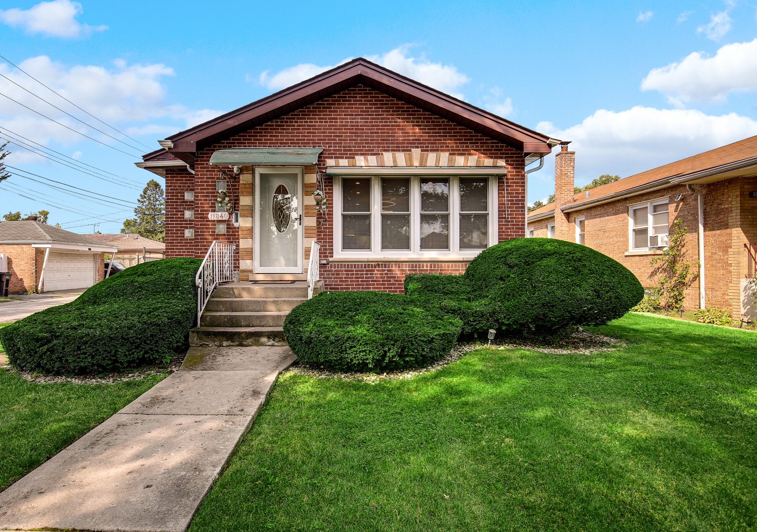 a front view of a house with a yard and plants