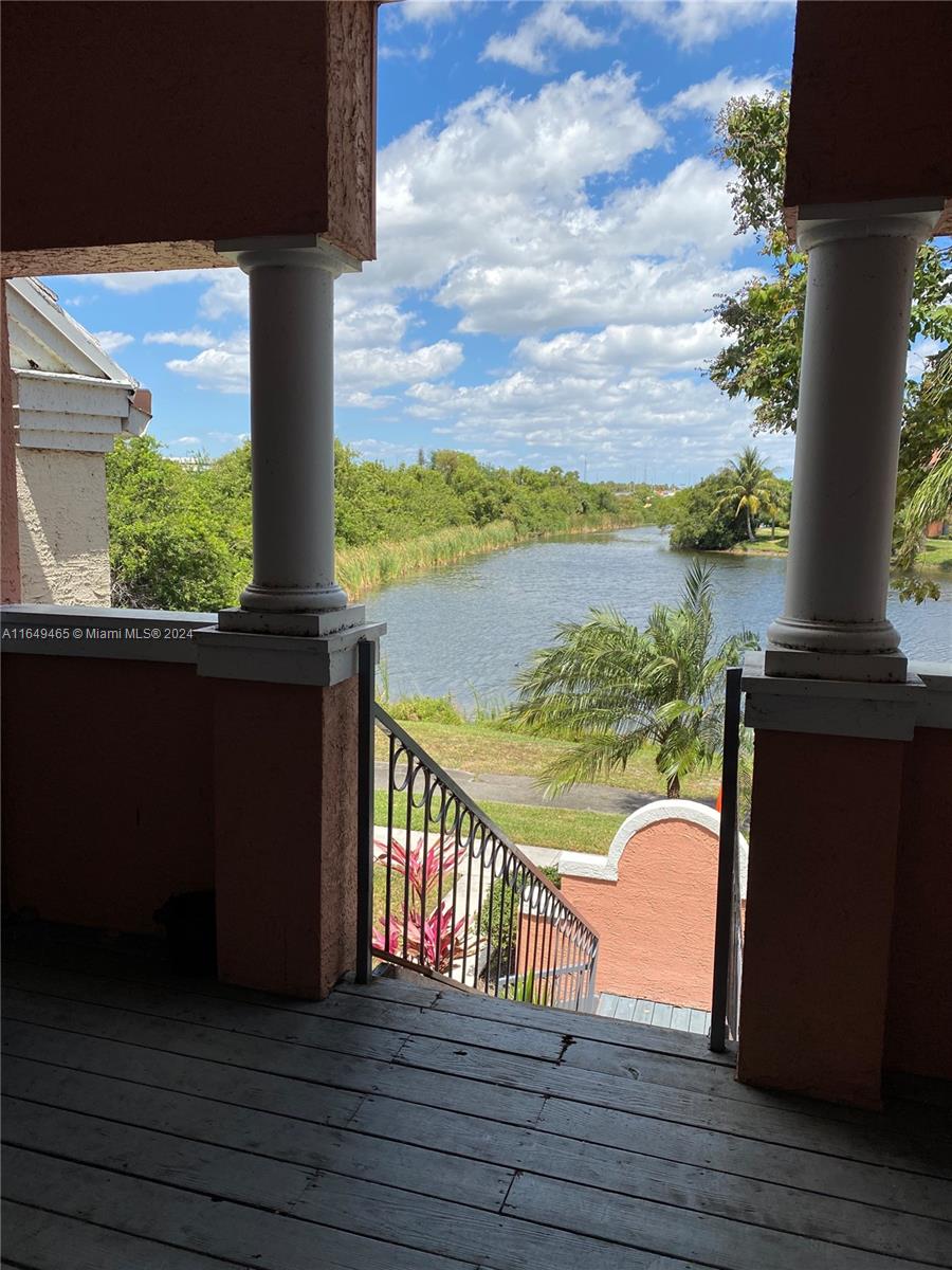 a view of a balcony with chair and wooden floor