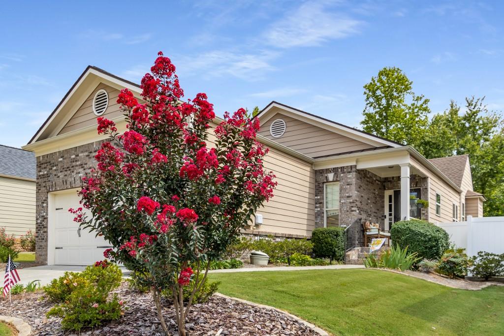 a front view of a house with a yard and potted plants