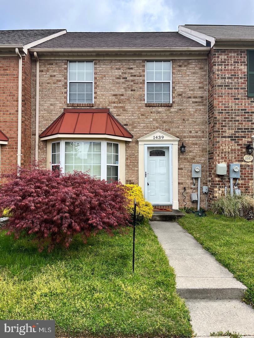 a front view of a house with a garden and plants