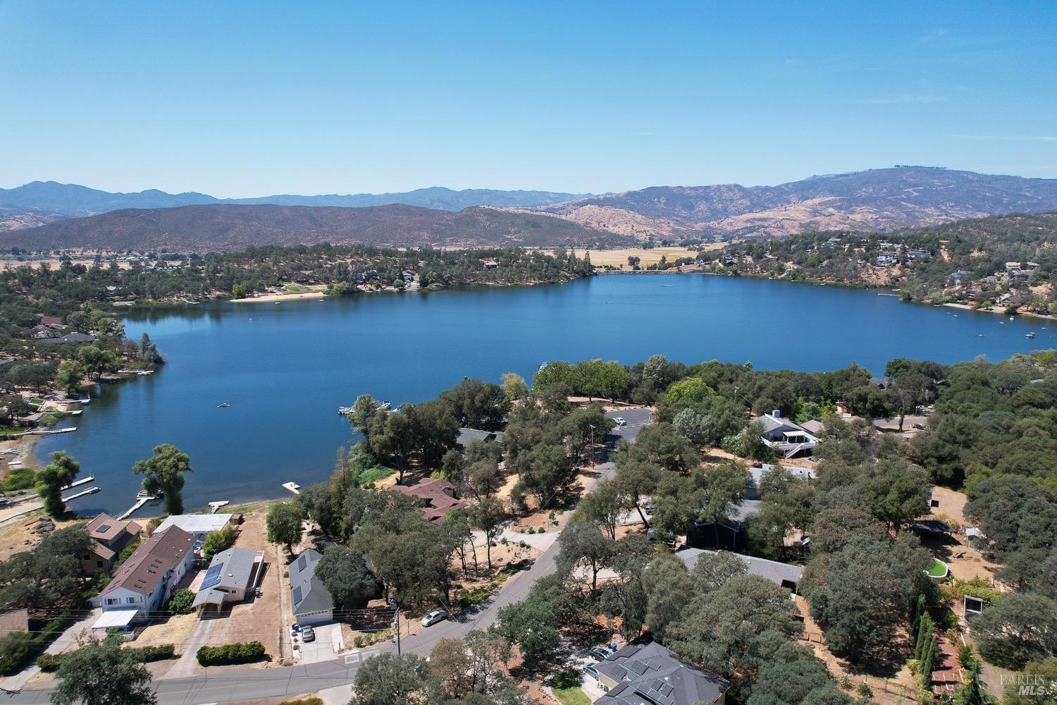 An aerial view of Hidden Valley Lake, boasting102 surface acres of water with 2 manicured beaches, BBQ pits, picnic tables, playgrounds, volley ball court, 2 large dive rafts, boat dock and easy launch pads for paddle boarding and kayaking! This lot is located in the safe and secure gated community of Hidden Valley Lake.