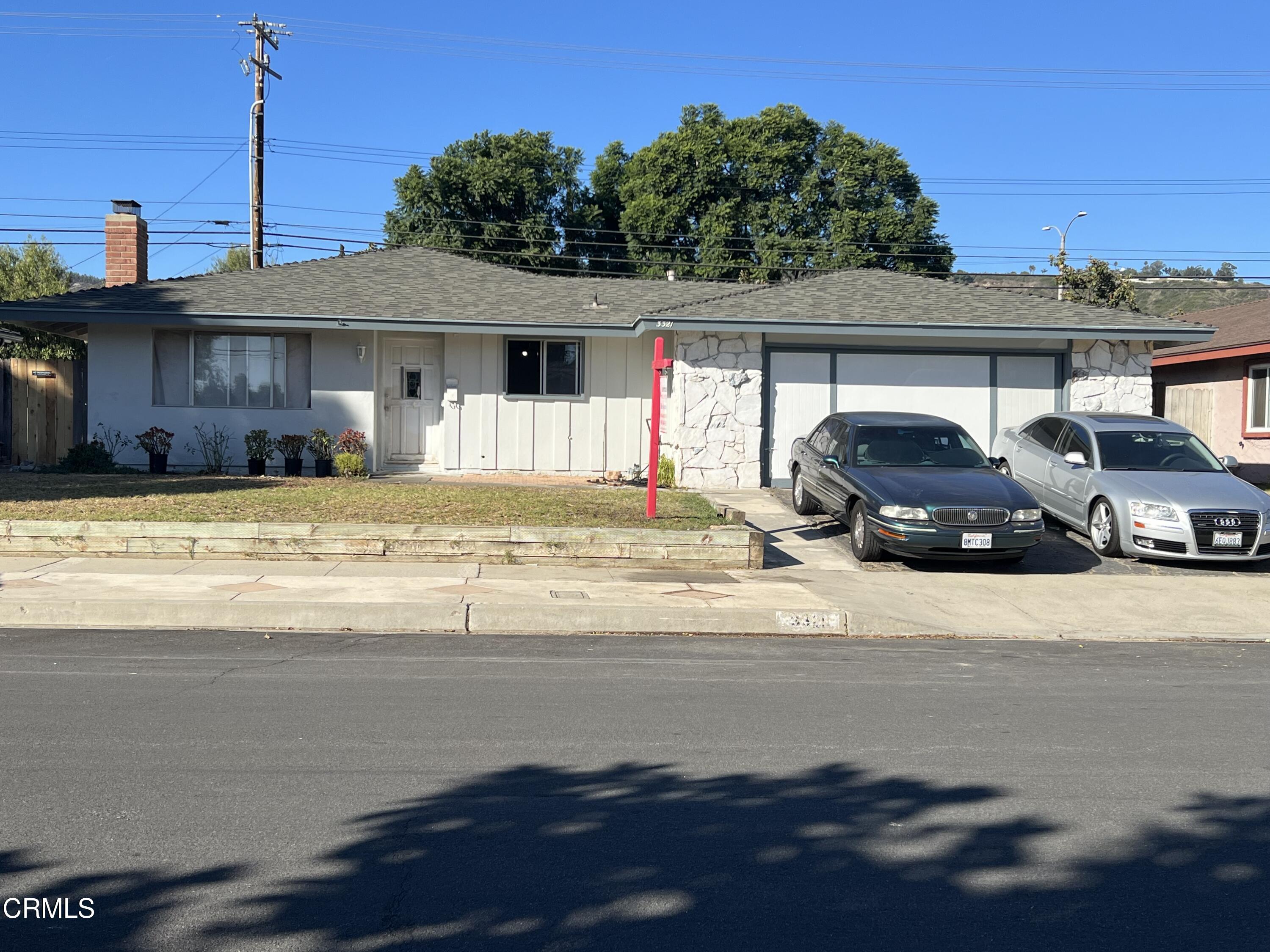 a front view of a house with cars parked