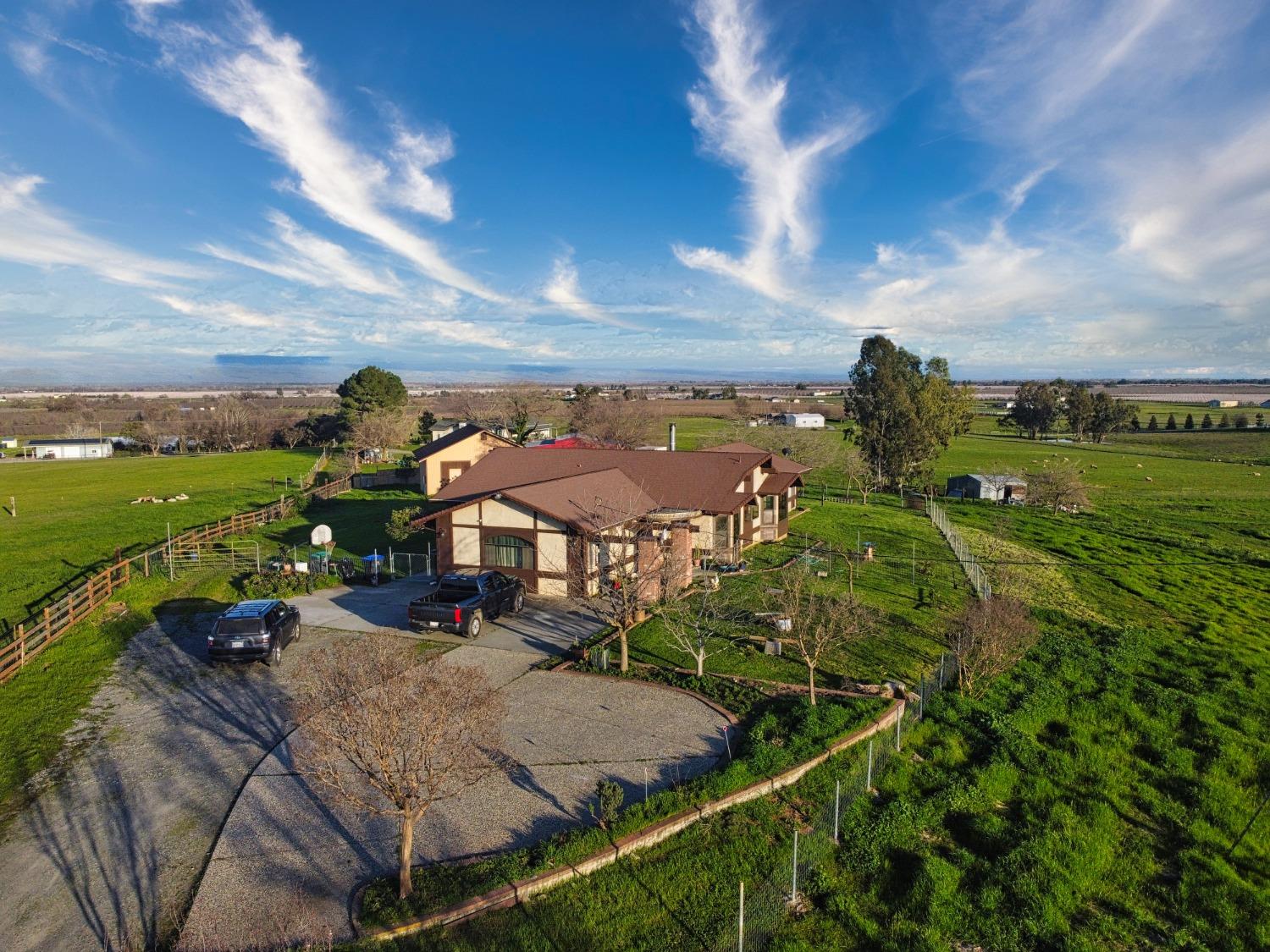 an aerial view of residential houses with outdoor space and trees