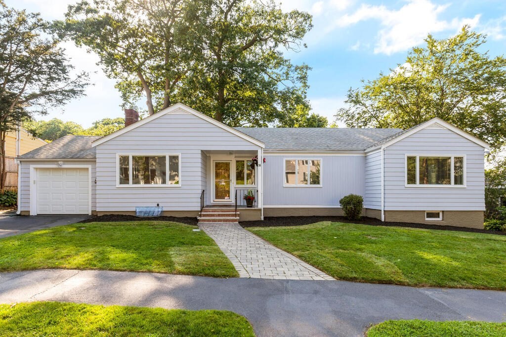 a front view of a house with a yard and trees