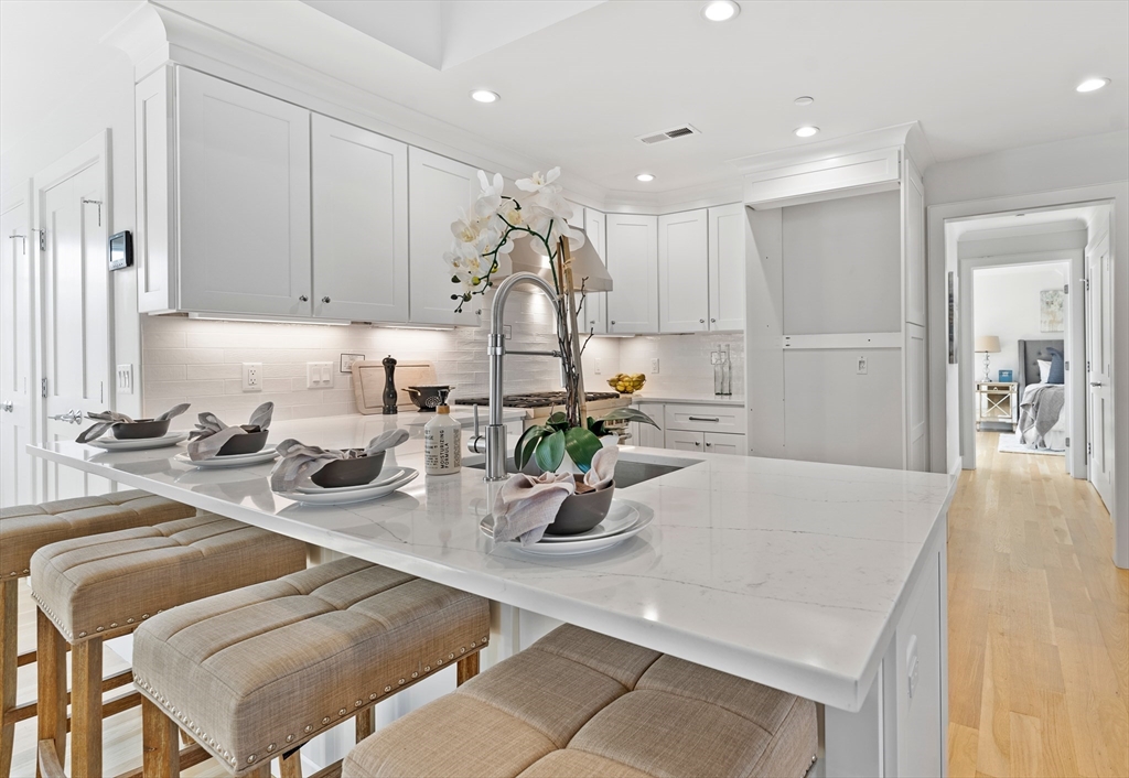 a kitchen with a sink dishwasher and a refrigerator with wooden floor