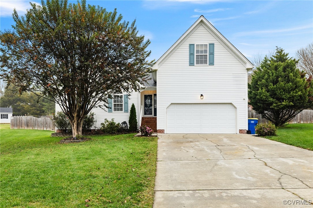 View of front property with a front lawn and a gar