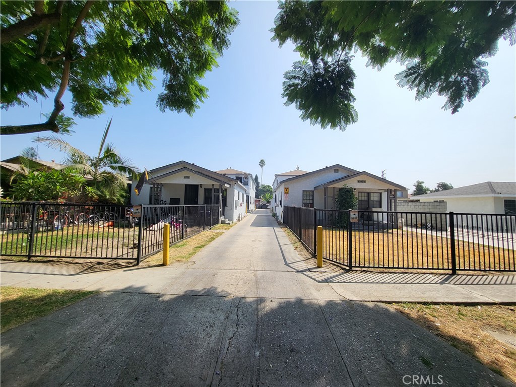 a view of a house with a small yard and wooden fence