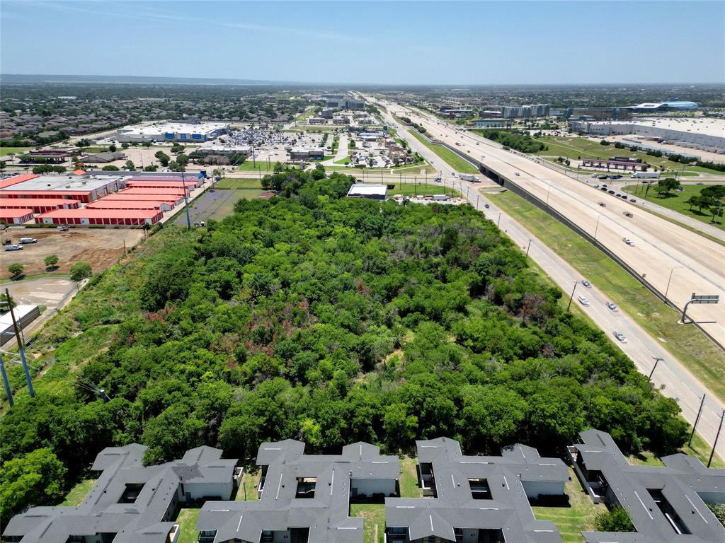 an aerial view of a city with lots of residential buildings ocean and mountain view in back