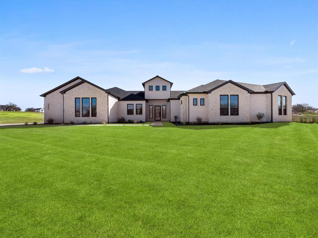 a view of a big house with a big yard and large trees