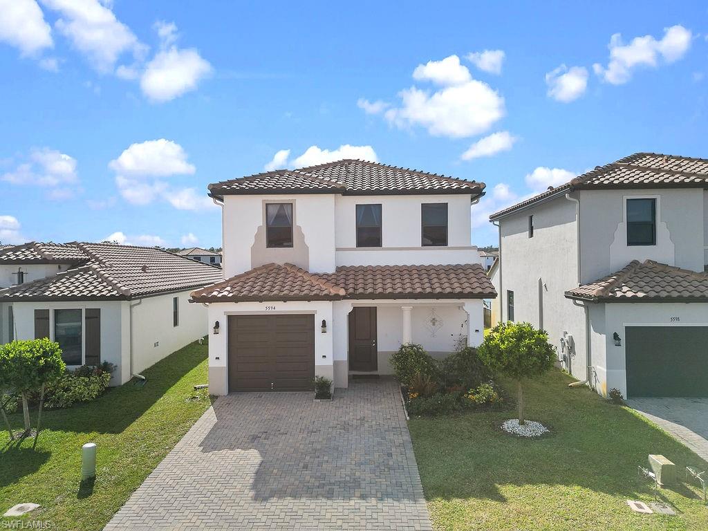 Mediterranean / spanish-style home with a front yard and a garage