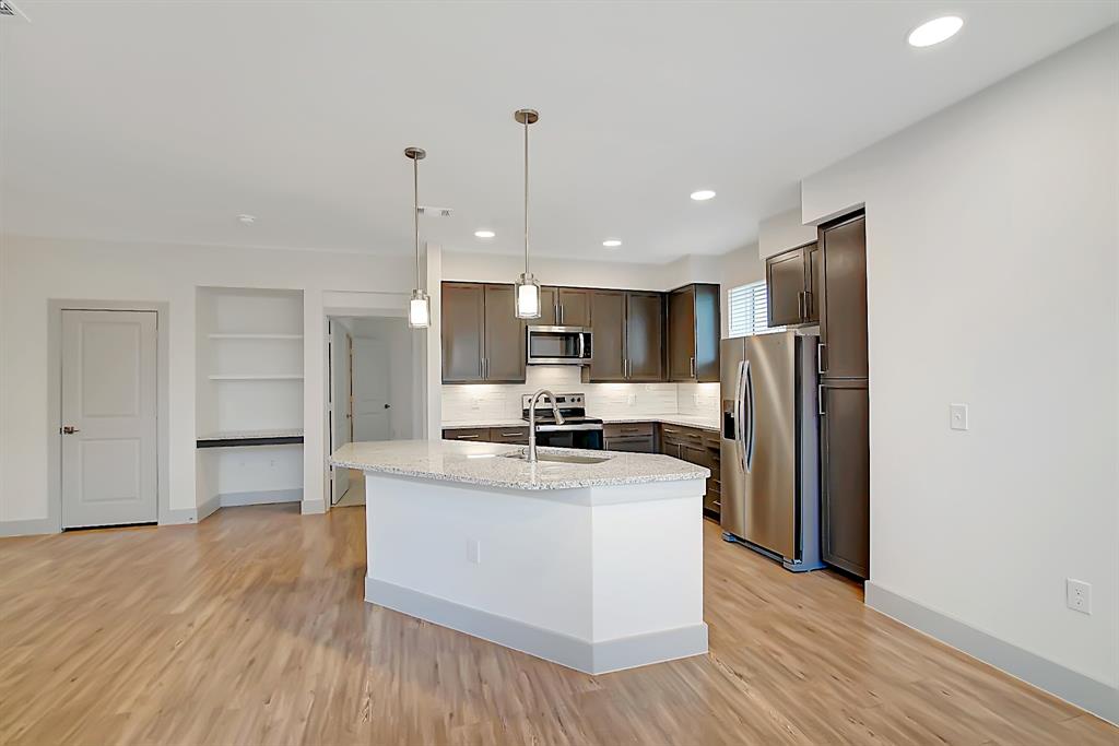 a kitchen with stainless steel appliances a refrigerator and a stove top oven