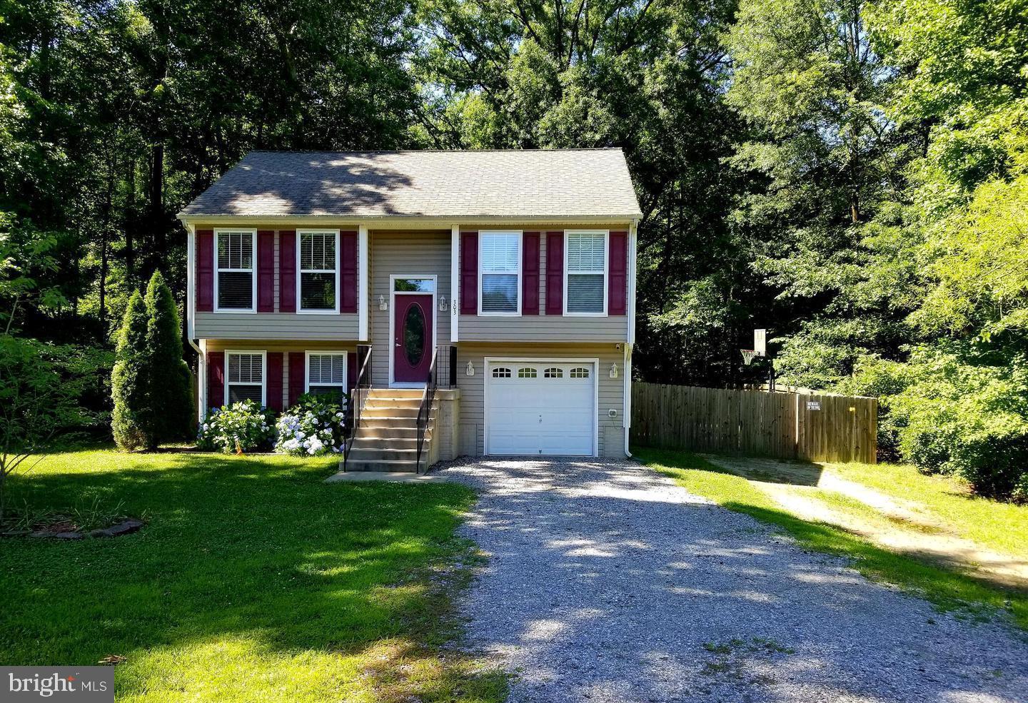 a front view of house with yard and trees in the background