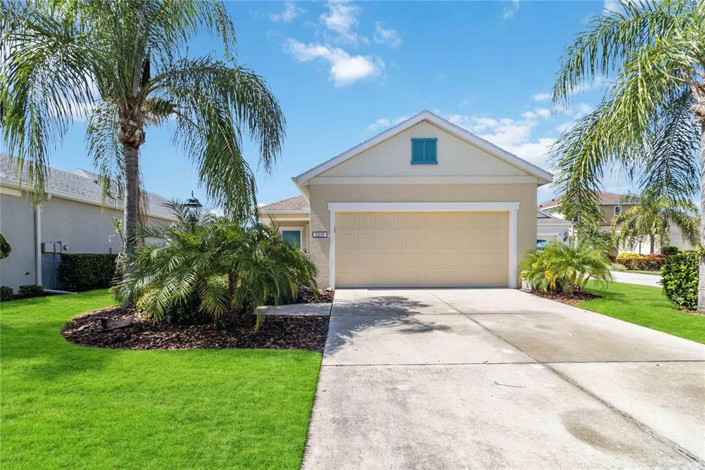 a view of a house with a yard and palm trees