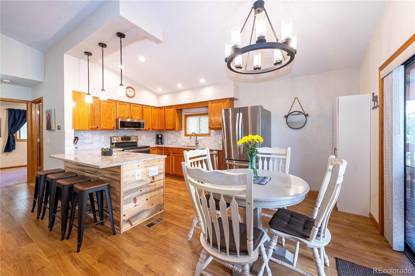 a view of a dining room with furniture a chandelier and wooden floor