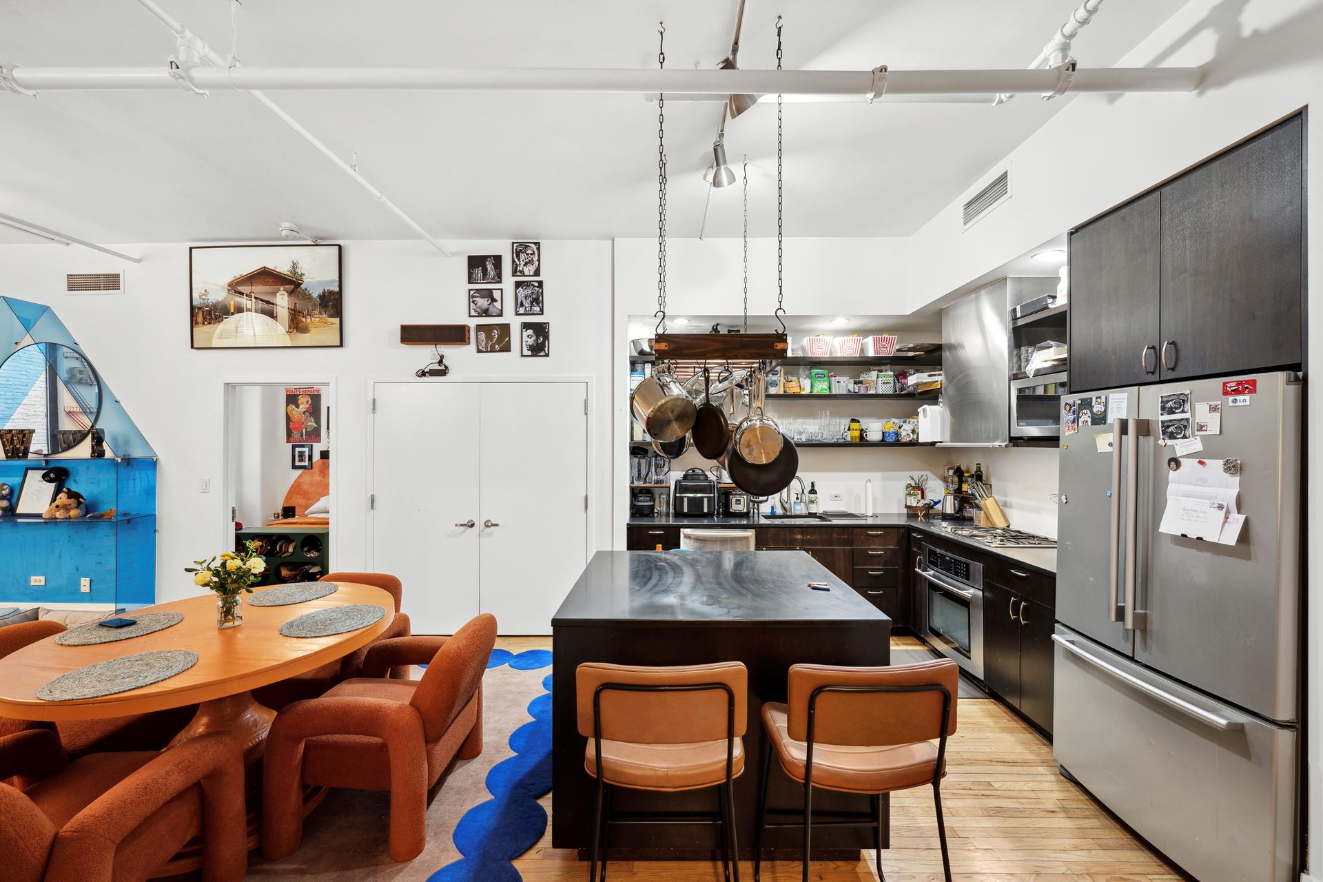 a kitchen with stainless steel appliances granite countertop a dining table and chairs