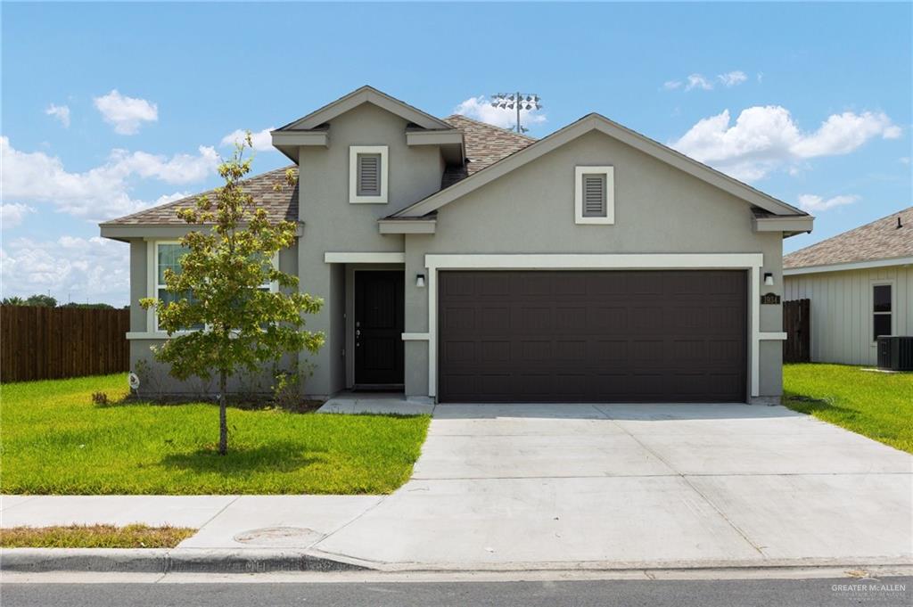 View of front property with a garage and a front yard