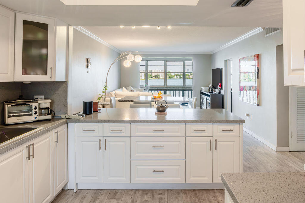 a kitchen with white cabinets and sink