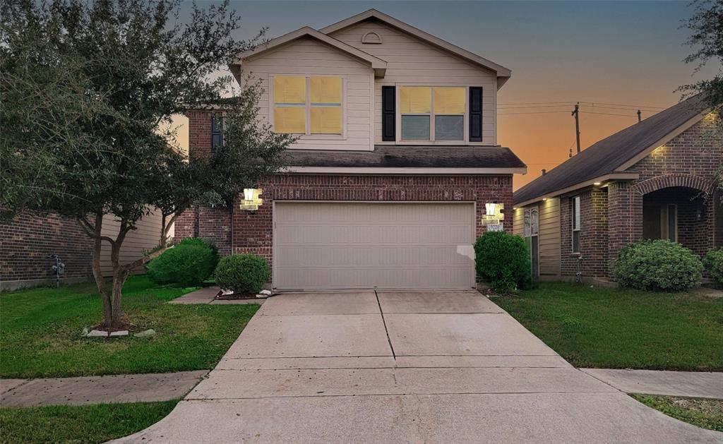 a front view of a house with a yard and trees