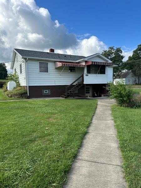 a front view of house with yard and green space