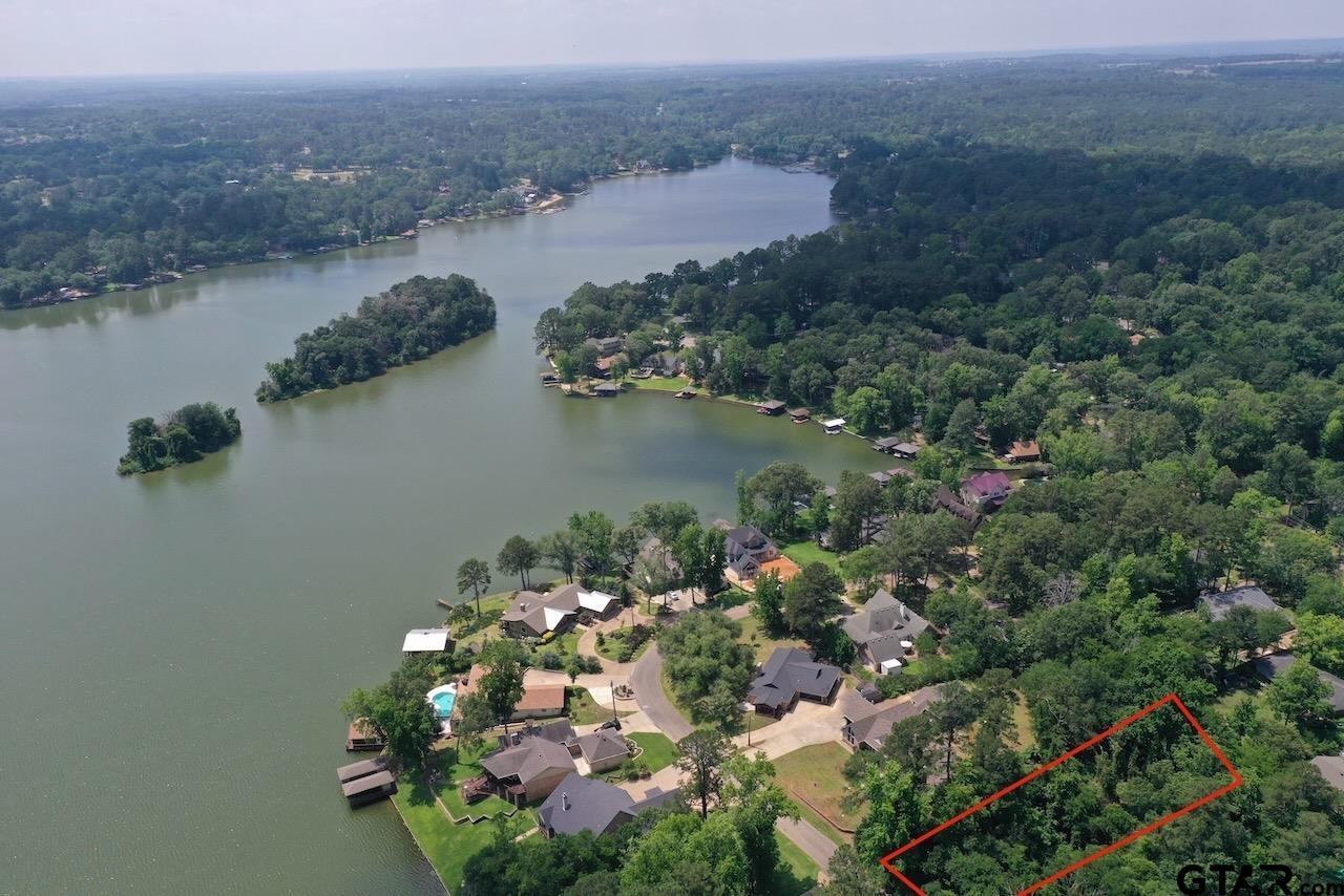 an aerial view of a house with a yard and lake view