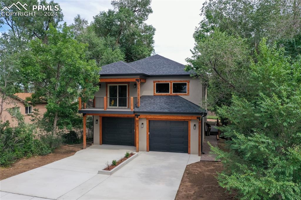 a front view of a house with yard and trees