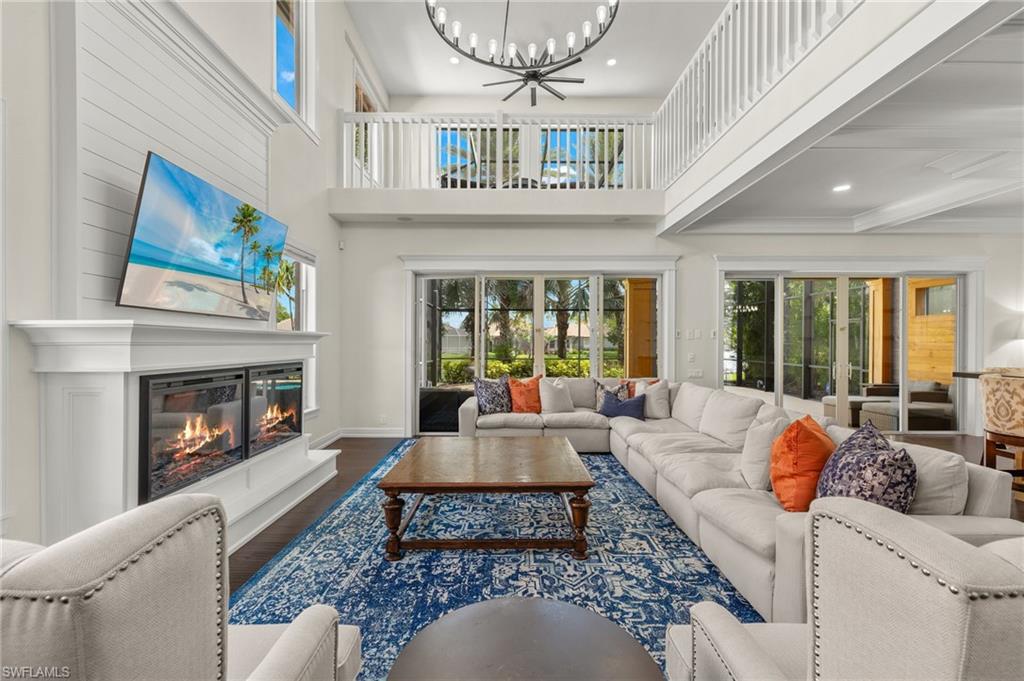 Living room featuring a high ceiling, wood-type flooring, and a chandelier