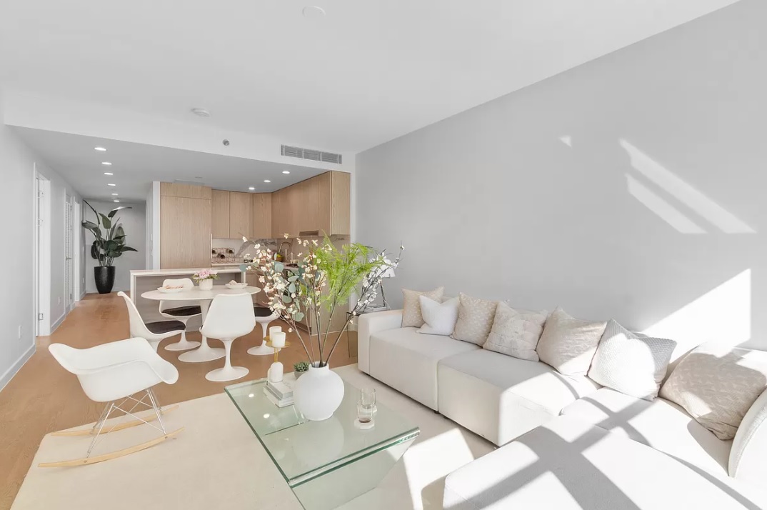 a living room with furniture and a dining table with kitchen view