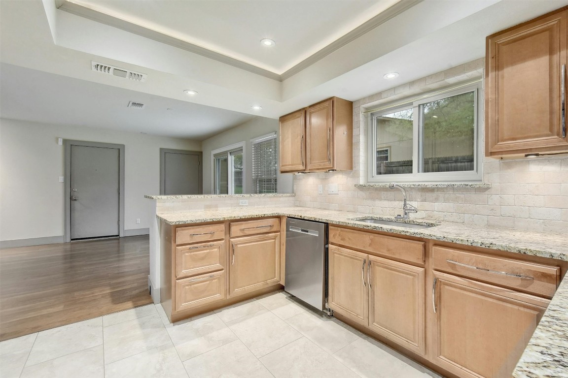 a kitchen with granite countertop cabinets sink and white stainless steel appliances