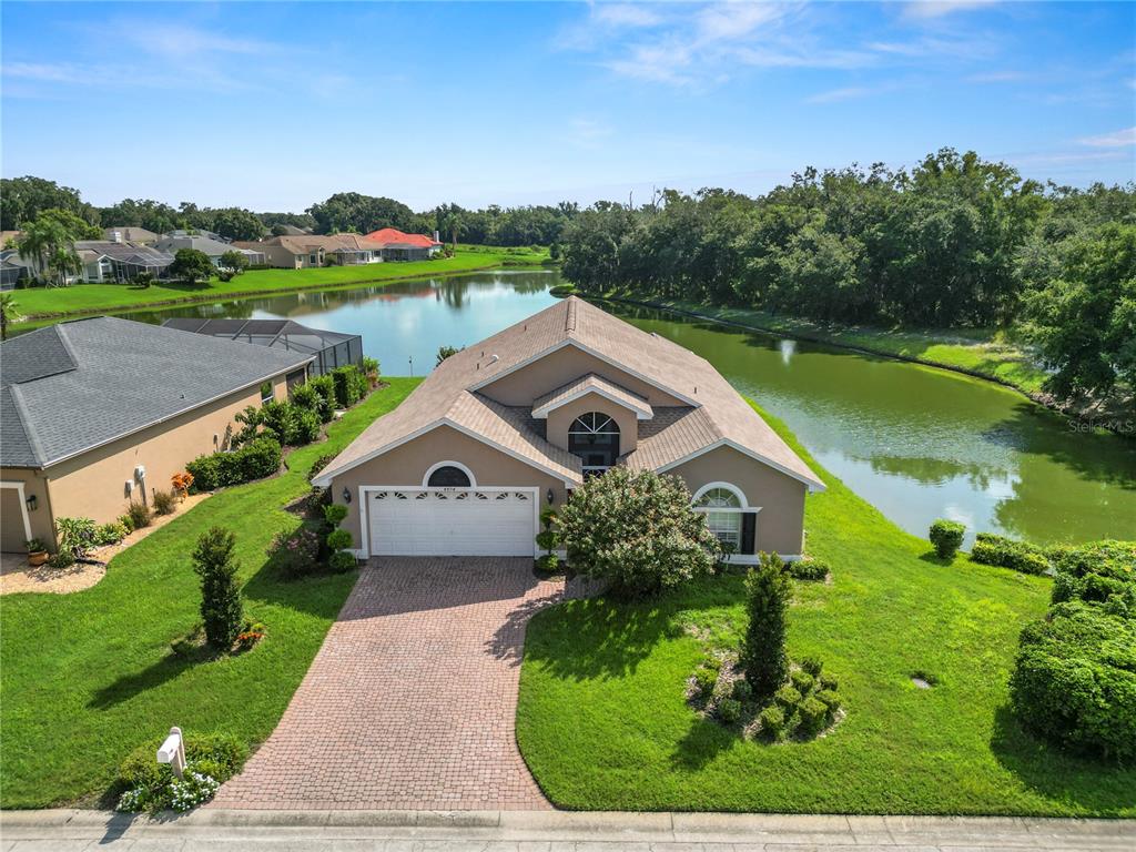 an aerial view of a house with a yard and lake view