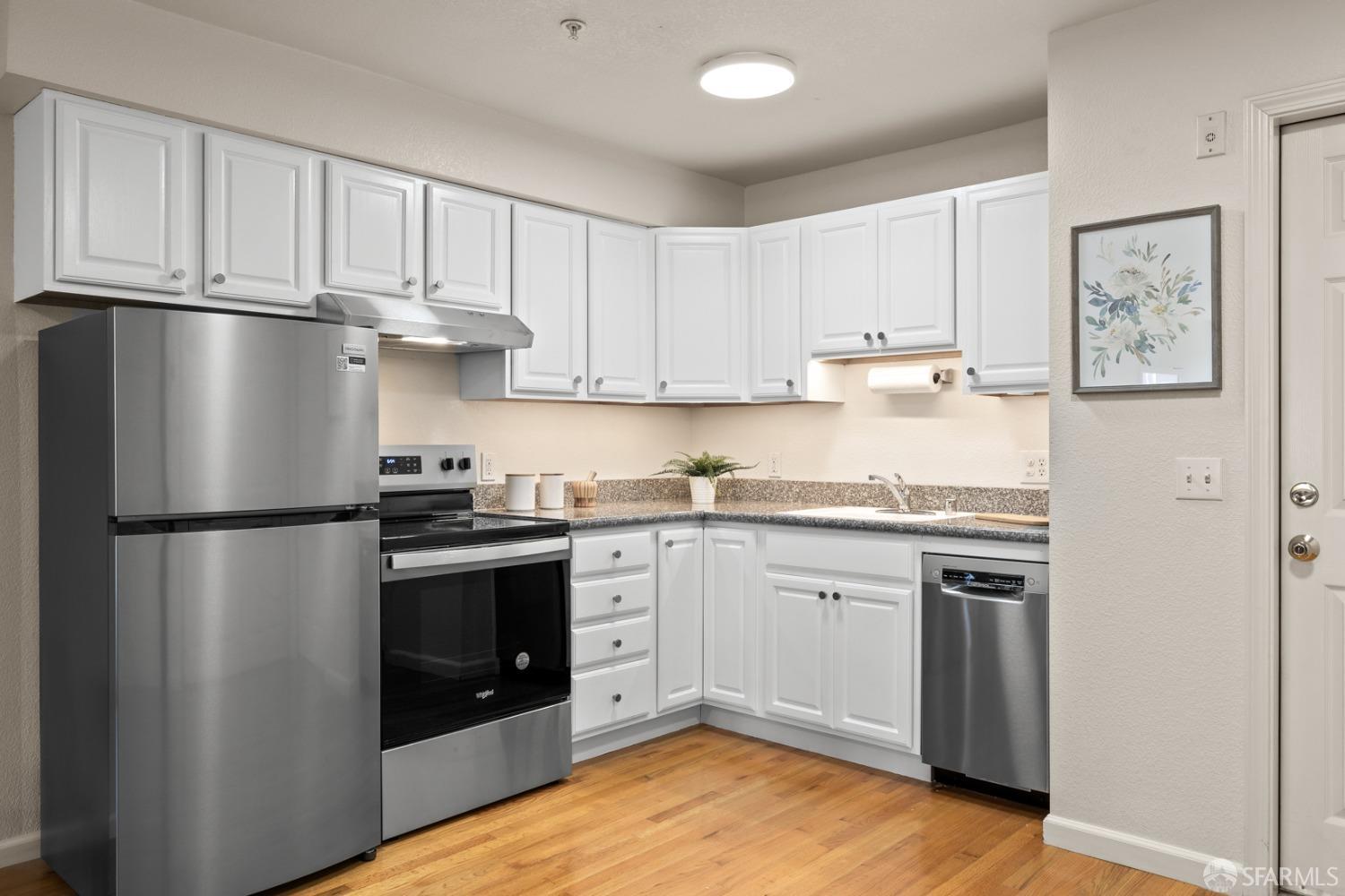 a kitchen with stainless steel appliances granite countertop a refrigerator sink and cabinets