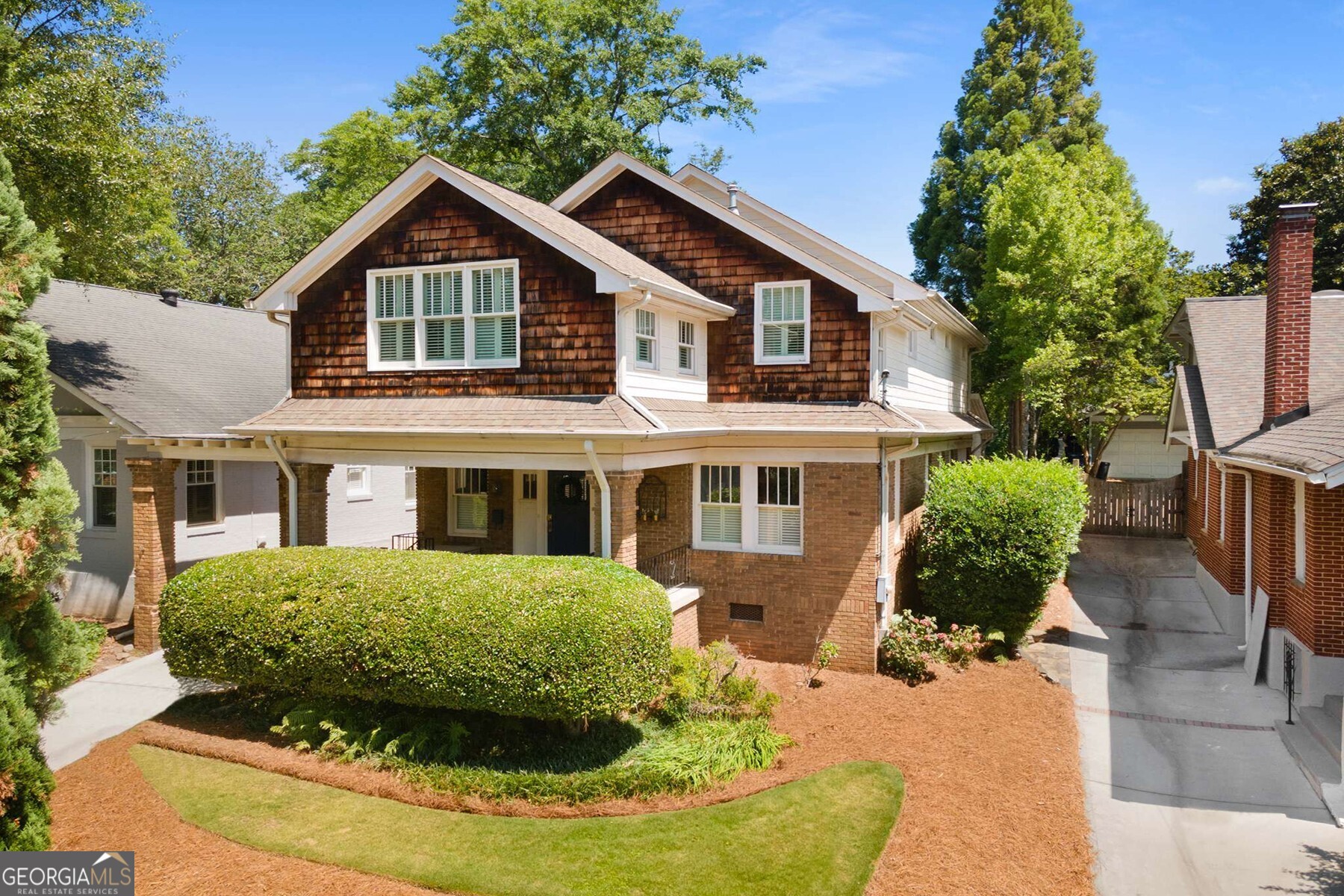 a view of a house with a yard and potted plants