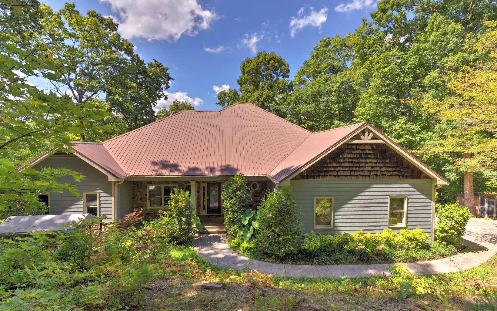 a front view of a house with a yard and trees