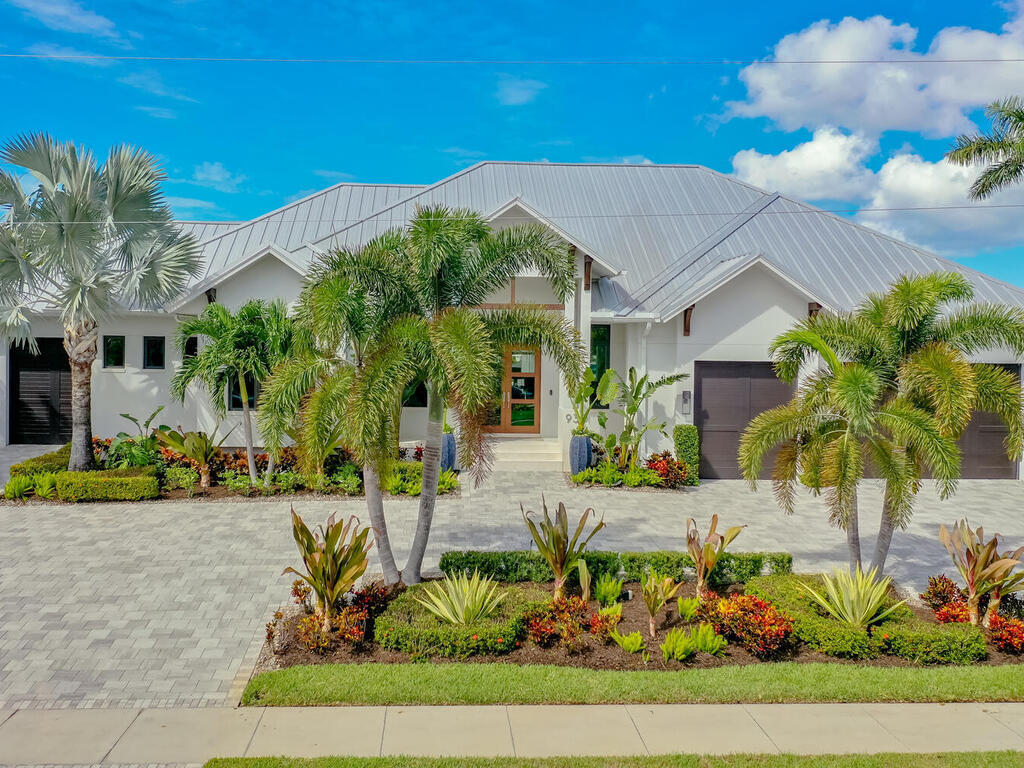 a front view of a house with a yard and potted plants