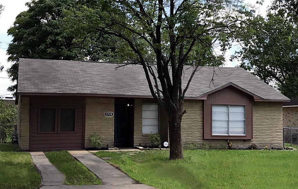 a front view of a house with a garden and yard