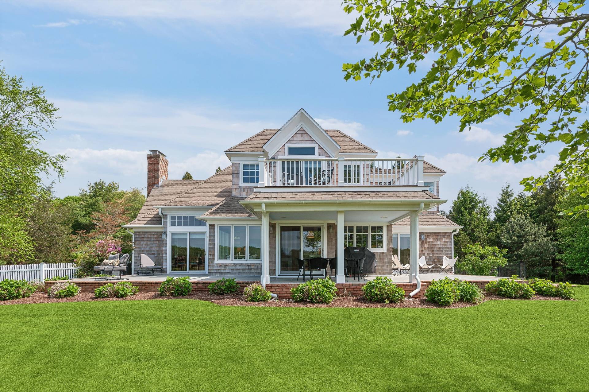 a front view of a house with a garden and trees